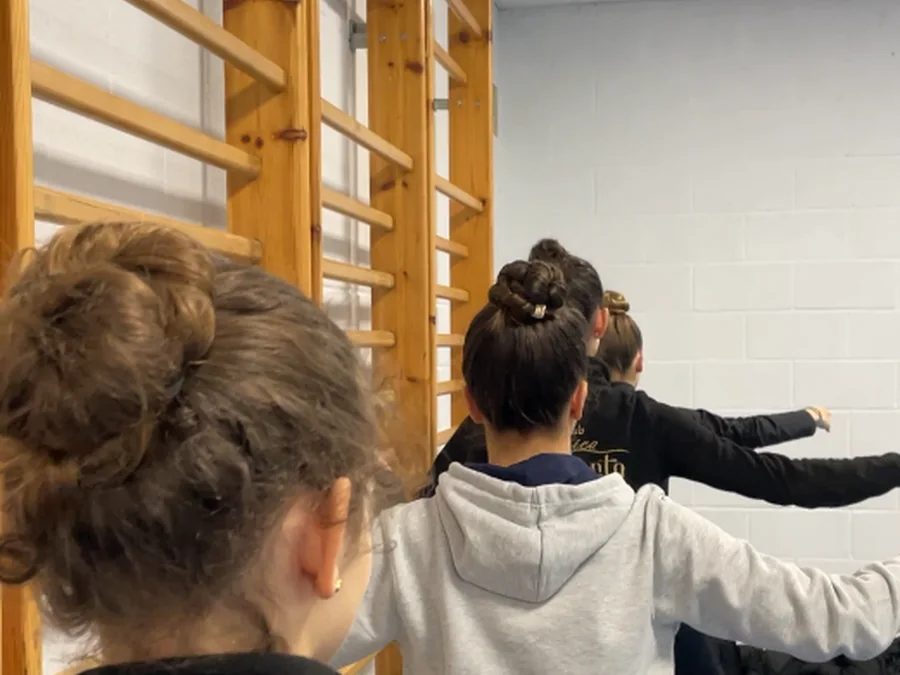 Alumnas de una extraescolar de danza de In Stage trabajando en la barra de espalderas de su colegio